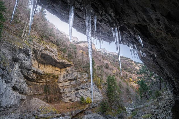 From below clean icicles hanging on rough stone formation against mountain slope in daytime in Ordesa y Monte Perdido National Park in Spain JuanLopez_ID709_25753_008 Copyright: xJuanxLopezx Model Released