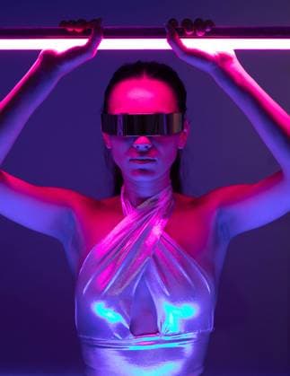 Self assured young female model with long hair in futuristic outfit and VR goggles standing in dark room with neon sword in hands, Model released MaciaPuiggros_ID813_30057_002 Copyright: xMaciaxPuiggrosx MR