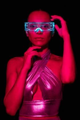 Creative Highlights Symbolbilder Serious focused young female experiencing virtual reality in modern transparent VR glasses in dark studio with bright pink neon illumination, Model released MaciaPuiggros_ID813_30072_016 Copyright: xMaciaxPuiggrosx MR