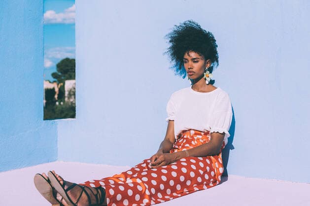 Creative Highlights Symbolbilder Black woman sitting in a colorful geometric building roof terrace, Model released DavidPrado_MurallaRoja_87 Copyright: xDavidxPradox MR