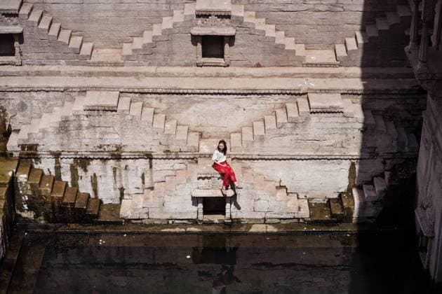 IMAGO Creative, Jahreszeit Sommer, Sommer in der Stadt From above young ethnic female tourist sitting on steps of Toorji well with water during sightseeing in India, Model released JuanAlbertoRuiz_ChiaInIndiaPart2_21 Copyright: xJuanxAlbertoxRuizx MR