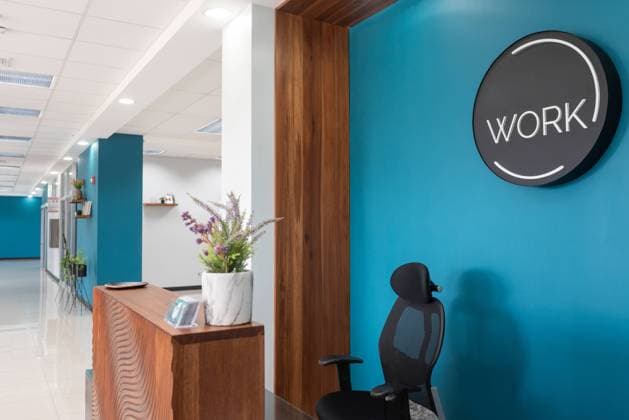 Comfortable chair at reception desk in modern office space with blue wall, Property released LeonardoBorges_CoworkingInCostaRica_4 Copyright: xLeonardoxBorgesx Model Released