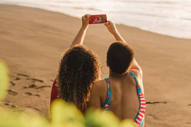 Creative Highlights Symbolbilder Back view of unrecognizable young ethnic women taking selfie on mobile phone while enjoying summer vacation together on sandy seashore in Costa Rica, Model released LeonardoBorges_FriendsInTheBeachCostaRica_47 Copyright: xLeonardoxBorgesx MR