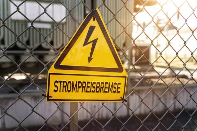 RECORD DATE NOT STATED 29 September 2022: Sign on a fence with the inscription: electricity price brake. Electricity price brake of the federal government PHOTOMONTAGE *** Schild an einem Zaun mit der Aufschrift: Strompreisbremse. Strompreis Bremse der Bundesregierung FOTOMONTAGE