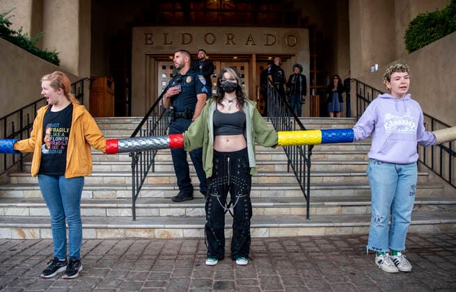 October 3, 2022, USA: From left, Annie Eilerman, Valkyrie Gyore and Marusya Airumrian, all from United World College, block the entrance to the Eldorado Hotel, in Santa Fe, where the New Mexico Oil and Gas Association is gathering. They are with around 50 protesters taking part in the demonstration, Monday, October 3, 2022. The protest is organized by YUCCA (Youth United for Climate Crisis Acrtion) is protesting against oil and gas exstraction in New Mexico. USA - ZUMAab1_ 20221003_zaf_ab1_012 Copyright: xEddiexMoorex