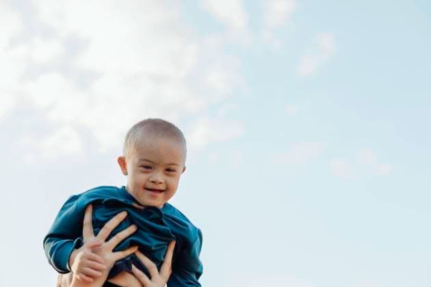Creative Highlights Symbolbilder Cute blond boy with down syndrome on mom s arms, blue sky background Barnaul, Altai Krai, Russia CR_AIAI220926-1045836-01 ,model released, Symbolfoto