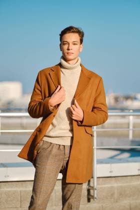 Creative Highlights Symbolbilder IMAGO Creative: Winter in der Stadt Frühling, Herbst Outfit. Straßenmode. Junger Mann in karierten Hosen, Pullover wickelt Wollmantel