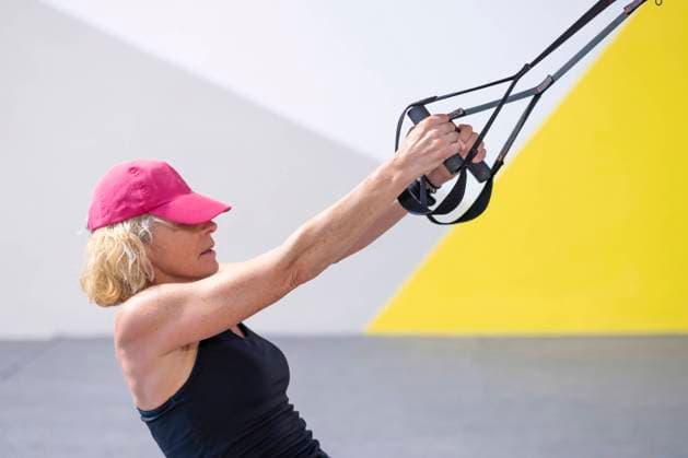IMAGO Creative, Neujahr, Vorsätze, Sport Real young mature caucasian woman in a sport wear at gym training arms exercises with trx fitness straps. Fitness concept. SPAIN Copyright: xMikelxBilbaox RF-M-22-08-043