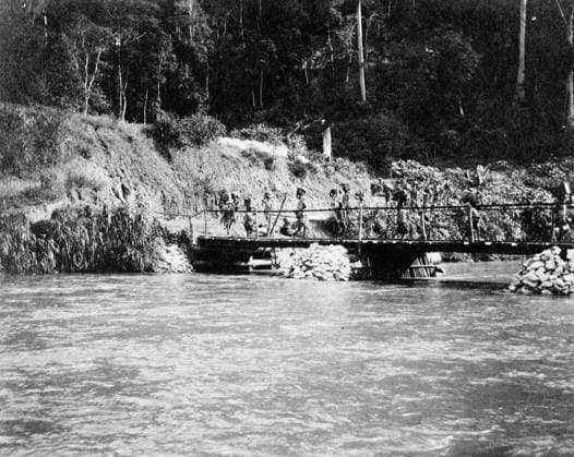 Ministry of Information First World War Official Collection German East African Campaign. Porters crossing Ruwu River at Ruwu Bottom, by the Pioneer Bridge, the old Bridge having been destroyed by the Germans. Copyright: xpiemagsx minofinfopieww04102022-109 !ACHTUNG AUFNAHMEDATUM GESCHÄTZT!