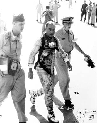 RECORD DATE NOT STATED (21 July 1961) --- Astronaut Virgil I. (Gus) Grissom, pilot of the Mercury-Redstone 4 (MR-4) Liberty Bell 7 spaceflight, arrives aboard the recovery ship, USS Randolph, following his 15-minute, 37-second suborbital space mission. He is flanked by military medical officers. 1062_36_M_-640-