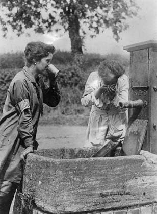 Ministry of Information First World War Official Collection College Girl flax workers having a drink at a pump on their way to work. Copyright: xpiemagsx minofinfopieww04102022-1349 !ACHTUNG AUFNAHMEDATUM GESCHÄTZT!
