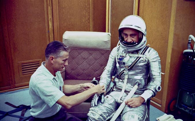 RECORD DATE NOT STATED (19 July 1961) --- Donning a spacesuit for the Mercury-Redstone 4 (MR-4) mission, astronaut Virgil I. (Gus) Grissom chats with spaceflight equipment specialist Joe W. Schmitt in the personal equipment room of Hanger S at Cape Canaveral, Florida. 1062_36_M_-2420-