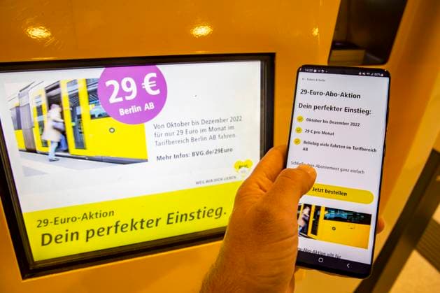 Eine Ticketautomat der BVG mit Werbung fuer den Abo mit dem 29 Euro Ticket und ein Handy mit der BVG App in Berlin am 1. Oktober 2022. Erster Tag des 29 Euro Ticket fuer den oeffentlichen Verkehr in Berlin - Features *** A BVG ticket vending machine advertising the 29 Euro ticket subscription and a cell phone with the BVG app in Berlin on October 1, 2022 First day of the 29 Euro ticket for public transport in Berlin Features
