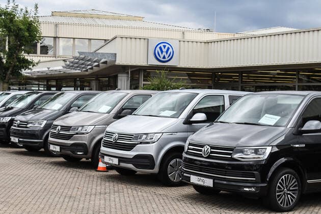 In langer Reihe stehen VW-Busse und Transporter auf dem Hof eines VW-Haendlers und warten auf Kaeufer.. *** VW buses and vans stand in a long row in the yard of a VW dealer, waiting for buyers.