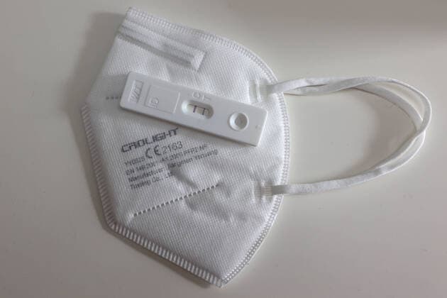Kommt die Maskenpflicht in Innenraeumen (Innenräumen) bald zurück (zurück)? Die zahlen steigen deutlich an. Positiv getestet, Corona Schnelltest liegt auf einer FFP2 Maske und zeigt an, dass die getestete Person mit dem Corona Virus infiziert ist Corona Schnelltest, Maskenpflicht am 13.10.2022 in Siegen Deutschland.