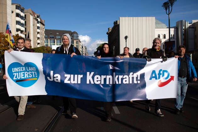 Deutsche Parteien: AfD, Symbolbilder AfD Demo - Unser Land Zuerst DEU, Deutschland, Germany, Berlin, 08.10.2022 Demonstrant mit Plakat Ja zur Kernkraft fuer Atomkraft und Atomkraftwerke auf einer Kundgebung und Demonstration der rechtsextremen Partei Alternative fuer Deutschland AfD unter dem Motto Unser Land Zuerst Energiesicherheit und Inflationsschutz im Regierungsviertel in Berlin, Deutschland. Der Protest gegen die Poltik der Bundesregierung, Energiepolitik, und steigende Preise und Inflation wird unterstuetzt von sog. Querdenker und Rechtsradikalen. Als Folge des Krieges in der Ukraine ist das Hauptthema fuer rechte Parteien in Deutschland jetzt die soziale Frage. en: Protester with placecard Nuclear power instead of a blackout for nuclear power and nuclear power plants