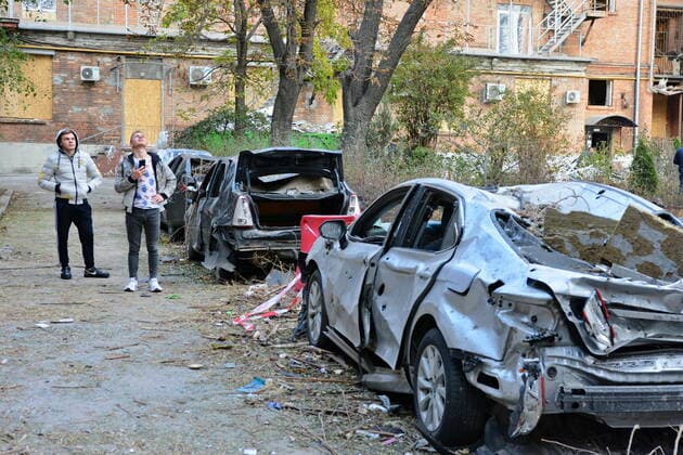 October 13, 2022, Kyiv, Ukraine: Men inspect damaged cars as a result of the Russian missile attack near the 101 Tower office building. After several months of relative calm, multiple explosions rocked Kyiv early on a Monday morning. The head of the Ukrainian military said that Russian forces launched at least 75 missiles in Ukraine, with fatal strikes targeting the capital Kyiv, and cities in the south and west. Kyiv Ukraine - ZUMAs197 20221013_zab_s197_023 Copyright: xAleksandrxGusevx
