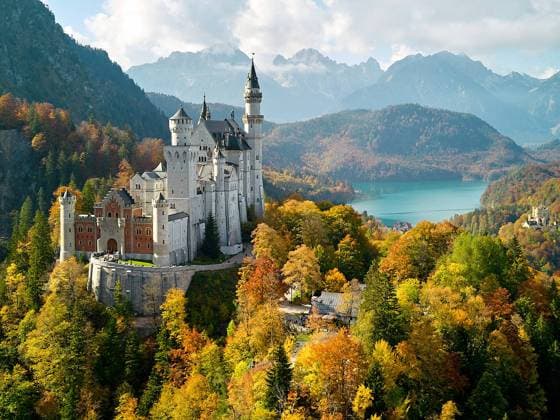 Schloss Neuschwanstein castle in Hohenschwangau with Marien bridge, and lake Alpsee and Schloss Hohenschwangau surrounded by colorful trees in autumn on Oct 12, 2022 in Schwangau, Germany.