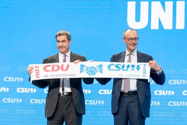 News Themen der Woche KW43 Parteitag der CSU 2022 in Augsburg - Markus Söder, Parteivorsitzender, über gibt an Friedrich Merz, Parteivorsitzender CDU, nach dessen Gastrede einen CDU-CSU-Schal auf der Bühne;Parteitag der CSU 2022 in Augsburg - Markus Söder, Parteivorsitzender, über gibt an Friedrich Merz, Parteivorsitzender CDU, nach dessen Gastrede einen CDU-CSU-Schal auf der Bühne, Augsburg Bayern Deutschland Messe *** Party Congress of the CSU 2022 in Augsburg Markus Söder, party leader, hands over to Friedrich Merz, party leader CDU, after his guest speech a CDU CSU scarf on stage Party Congress of the CSU 2022 in Augsburg Markus Söder, party leader, hands over to Friedrich Merz, party leader CDU, after his guest speech a CDU CSU scarf on stage, Augsburg Bav
