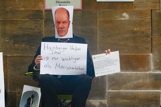 NRW, Solidaritätsdemonstration für die Frauen im Iran in Bonn Protest Demanding German s Sanction Against Iran Islamic Republic In Bonn a protester with German chancellor Olarf Scholz mask is seen with a sign Hamburger harbor deal is more important than people sitting in front of old chancellor office in Bonn, Germany on Oct 31, 2022 and demand immediate saction on Iran Islamic republic for crackdown on protest from Chancellor Scholz. Bonn Germany  Copyright: xYingxTangx originalFilename: tang-notitle221031_npjq7.jpg