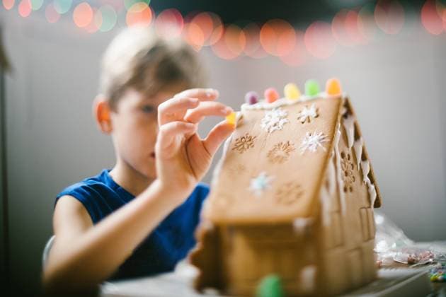 Boy places candy on gingerbread house with Christmas lights Gurnee, Illinois, United States CR_WVNP221020-1039551-01 ,model released, Symbolfoto