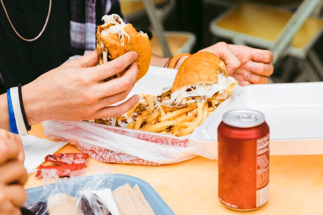 Hand of man holding steak and cheese sandwich at table model released, Symbolfoto, Los Angeles California USA ACTF00247