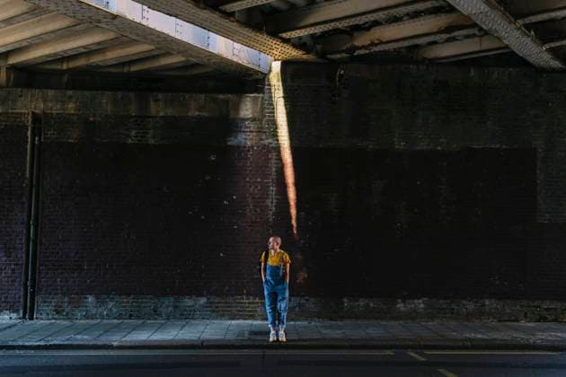 Young androgynous person waiting on sidewalk below bridge model released, Symbolfoto, ASGF03010
