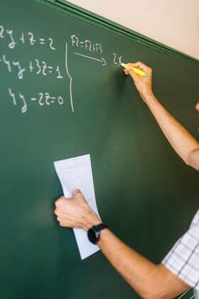 Math teacher writing on chalkboard in classroom model released, Symbolfoto, DAMF01090