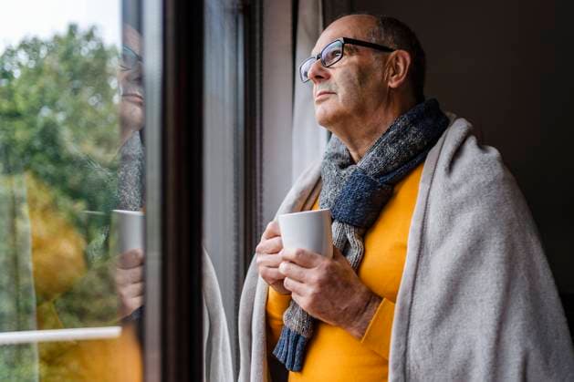 Thoughtful man with tea looking out of window at home model released, Symbolfoto property released, DIGF19032