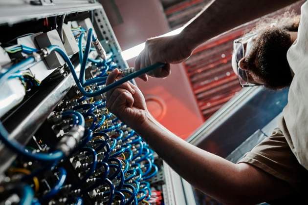 Technician connecting cables of server in data center model released, Symbolfoto property released, DSHF00593