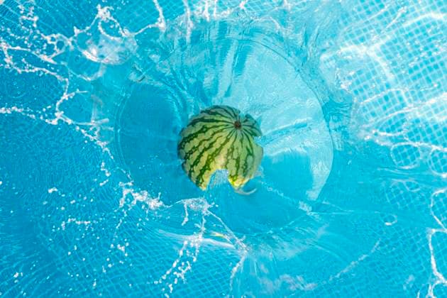 Watermelon falling into swimming pool, JAQF01044