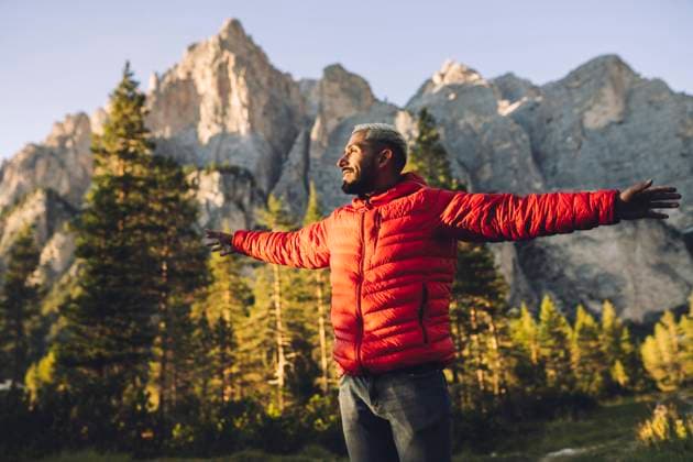 Smiling man with arms outstretched standing in front of Dolomites, Italy model released, Symbolfoto, JCCMF07345