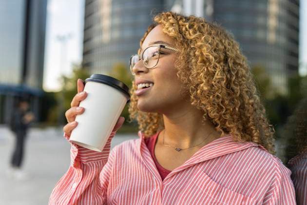 Smiling curly haired woman having coffee model released, Symbolfoto, JCCMF07637