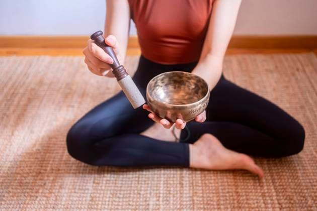Young woman playing Tibetan singing bowl at home model released, Symbolfoto property released, MMPF00295