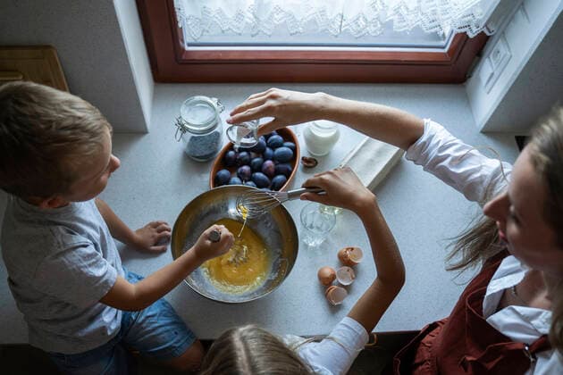 IMAGO Creative, Jahreszeit Sommer, Food, Pflaume Woman cooking cake of plums with children at home model released, Symbolfoto property released, NJAF00037