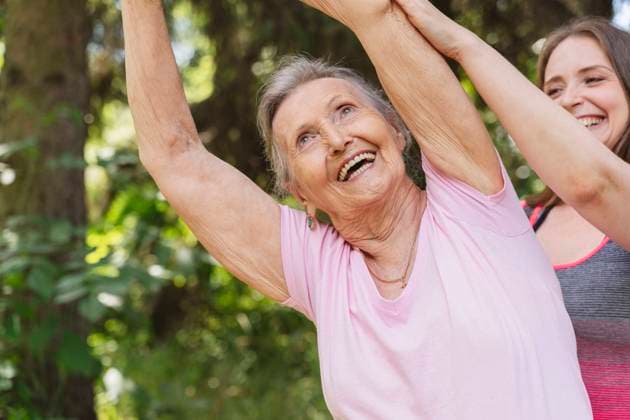 Happy fitness instructor guiding senior woman exercising at park model released, Symbolfoto, OSF01045