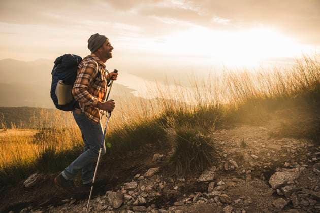 IMAGO Creative: November, Monat der Männergesundheit Happy mature man with backpack hiking at sunrise model released, Symbolfoto, UUF27591