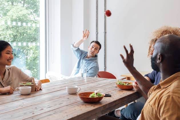 Businessman throwing apple at healthy lunch in staff room with colleagues model released, Symbolfoto property released, WESTF25075