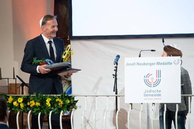 Preistraeger Hans Joachim WATZKE dankt einem Schueler des Albert Einstein-Gymnasiums fuer sein Geschenk, Verleihung der Josef Neuberger-Medaille 2022 der juedischen Gemeinde Duesseldorf an Hans Joachim Watzke, 03.11.2022
