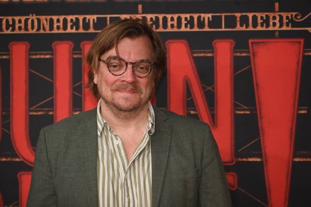 Moderator Nilz Bokelberg kommt über den roten Tepich bei der Galapremiere des Musical Moulin Rouge! Das Musical in den Kölner Musical Dome