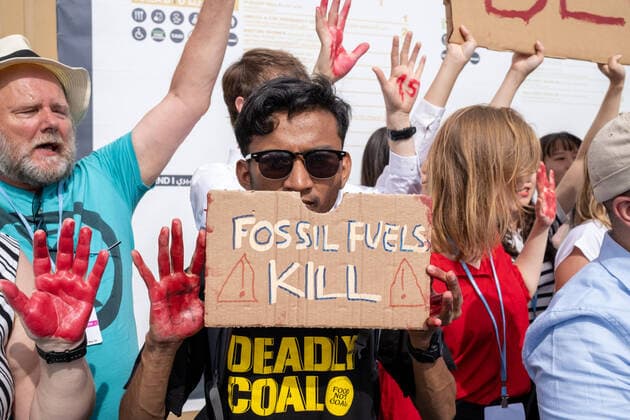 COP 27 Demonstartion Ägypten, Scharm El-Scheikh am 16.11.2022: Eine Demo auf dem Gelände der Klimakonferenz COP27. Ein Man hält ein Schild mit Fossil Fuels Kills , seiner Hände sind Blut-Rot bemahlt. Auf dem T-Shirt steht Deadlz Coal - Food not Coal *** COP 27 Demonstartion Egypt, Sharm El Sheikh on 16 11 2022 A demo on the site of the climate conference COP27 A man holds a sign with Fossil Fuels Kills , his hands are painted blood red On the T shirt says Deadlz Coal Food not Coal