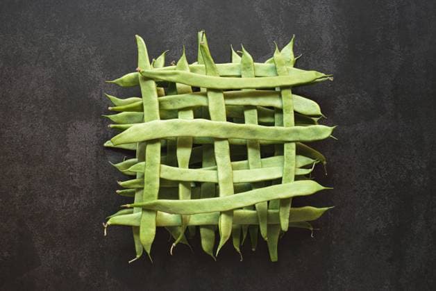 Top view of whole green beans in a geometric pattern on dark background Top view of whole raw green beans in a grid shape on dark background Copyright: xZoonar.com CsabaxDelix 17650522