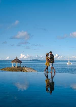 couple men and woman watching sunset on a tropical beach in Mauritius with palm trees by the swimming pool, Tropical sunset on the beach in Mauritius a couple of men and women watching the sunset on a tropical beach in Mauritius with palm trees by the swimming pool, Tropical sunset on the beach in Mauritius. Copyright: xZoonar.com FokkexBaarssenx 18623163 ,model released, Symbolfoto ,property released