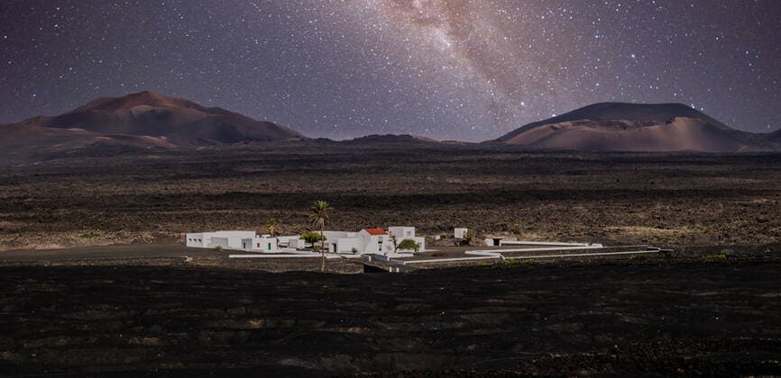 Amazing nocturnal panoramic landscape of volcano craters in Timanfaya national park. Milky way stars on night sky over La Gueria, Lanzarote island, Canary islans, Spain Amazing nocturnal panoramic landscape of volcano craters in Timanfaya national park. Milky way stars on night sky over La Gueria, Lanzarote island, Canary islans, Spain. Copyright: xZoonar.com MatejxKastelicx 18871649