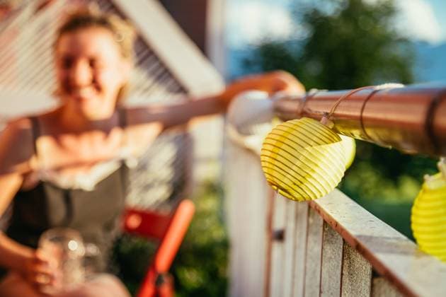 Summer feeling on the balcony: Close up of lampions, smiling girl in the blurry background Close up of summer lampions on a balcony, girl in the blurry background. Leisure time in the summer holidays Copyright: xZoonar.com PatrickxDaxenbichlerx 14031644 ,model released, Symbolfoto ,property released