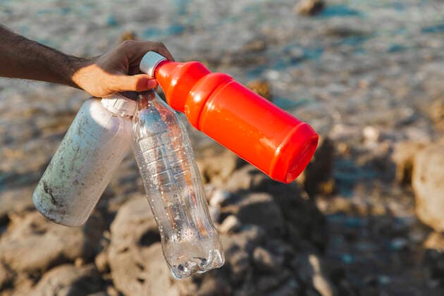 Hand of man holding empty plastic bottles at beach model released, Symbolfoto, PCLF00192