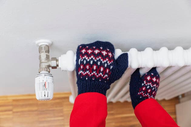 Hands of senior man wearing woolen glove on radiator model released, Symbolfoto, GWF07612