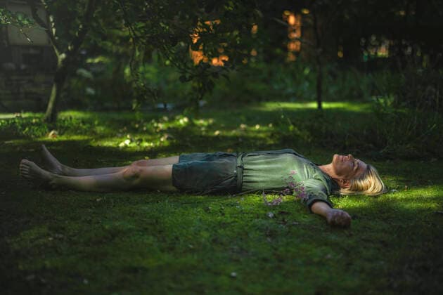 Woman with arms outstretched lying on grass model released, Symbolfoto property released, RIBF01173