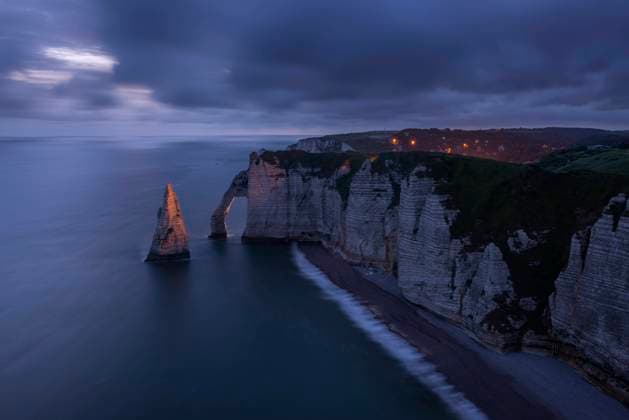 France, Normandy, Etretat, Falaise dAval cliffs and Aiguille dEtretat sea stack at cloudy dusk, RUEF03855