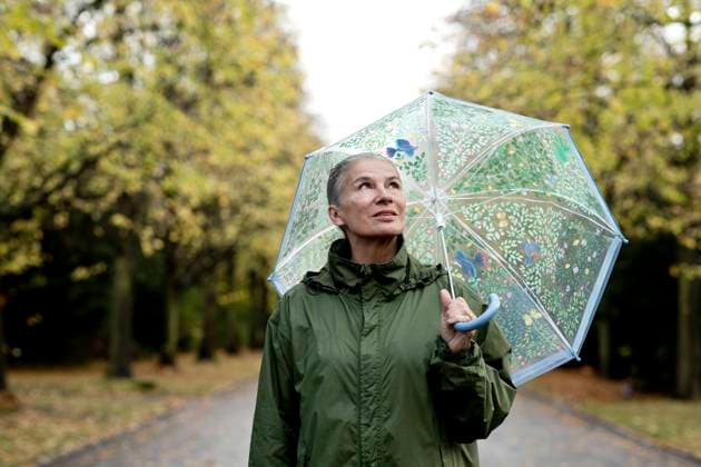 Contemplative senior woman with raincoat and umbrella model released, Symbolfoto, FLLF00805